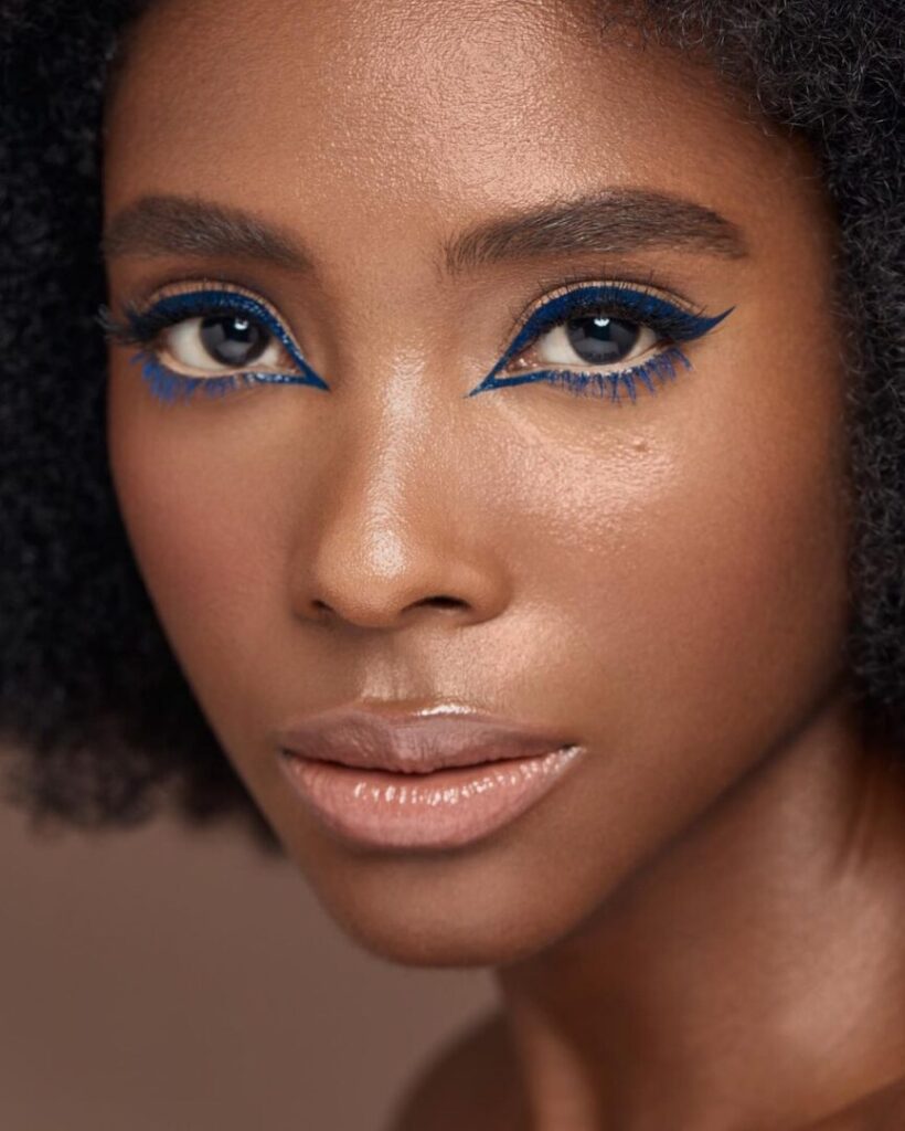 Modelo Brigitte Calegari usando maquiagem com delineado azul escuro
