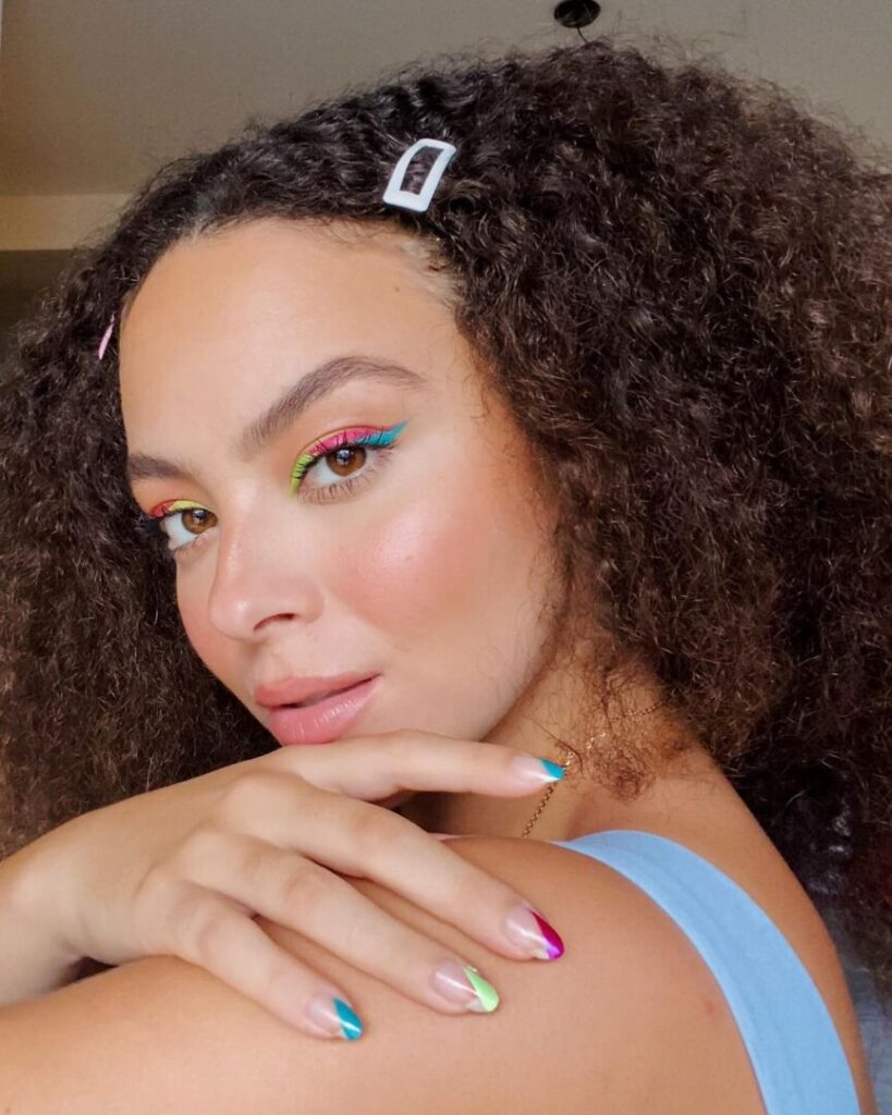 Julia Rodrigues usando delineado verde, rosa e azul