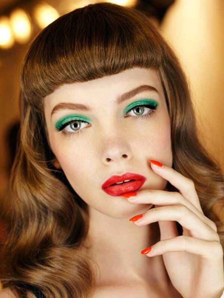modelo usando maquiagem para o Natal com sombra verde e batom vermelho