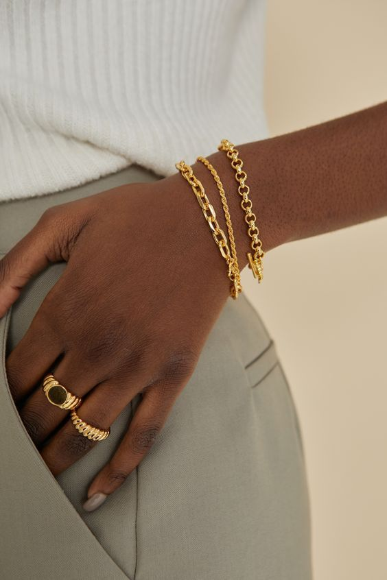 modelo usando anéis e pulseiras dourados para moda verão